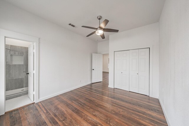 unfurnished bedroom featuring connected bathroom, dark wood-style flooring, visible vents, baseboards, and a closet
