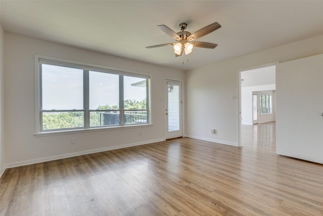 unfurnished room featuring a ceiling fan, plenty of natural light, light wood-style flooring, and baseboards