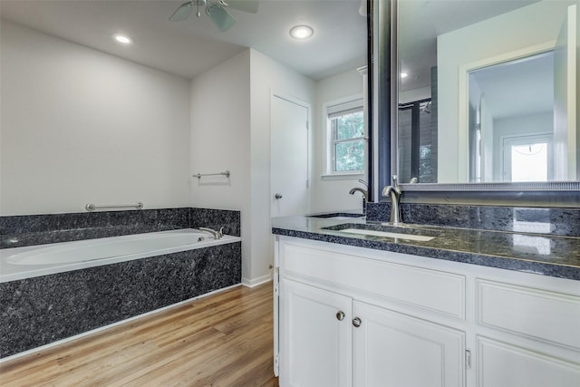 bathroom featuring recessed lighting, a ceiling fan, vanity, wood finished floors, and a bath