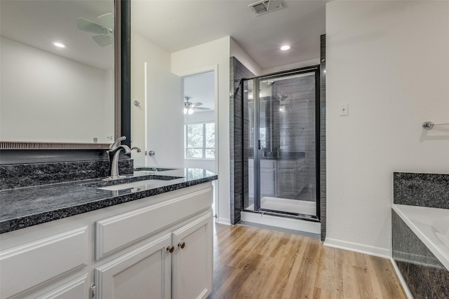 full bathroom featuring vanity, wood finished floors, visible vents, and a shower stall