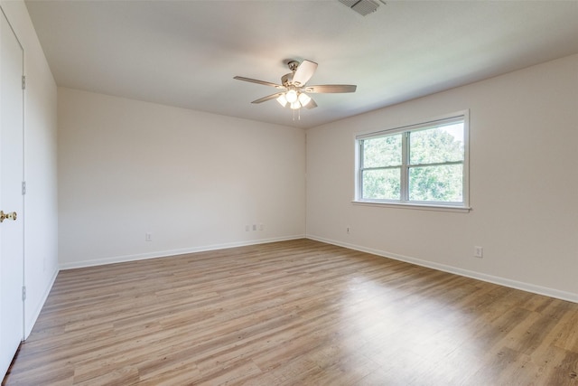 unfurnished room with light wood finished floors, ceiling fan, visible vents, and baseboards