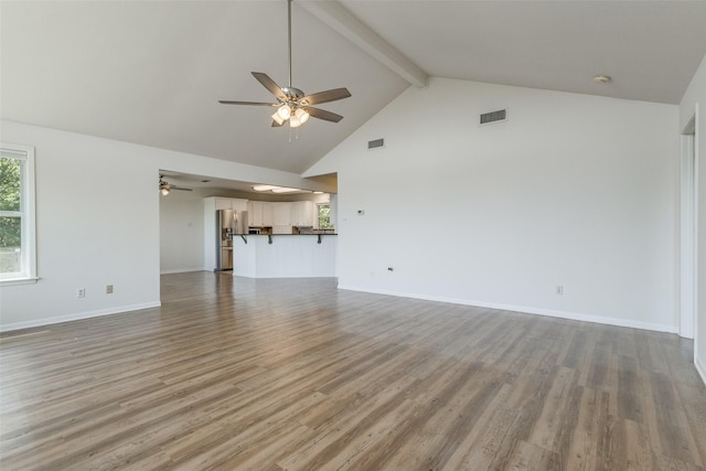 unfurnished living room with ceiling fan, high vaulted ceiling, visible vents, light wood-type flooring, and beamed ceiling