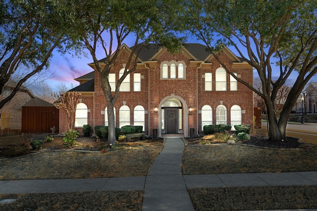 view of front of property with fence and brick siding