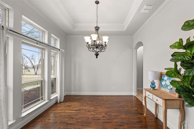 unfurnished dining area with dark wood-style floors, a tray ceiling, arched walkways, visible vents, and an inviting chandelier