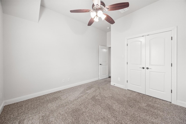 unfurnished bedroom with carpet, baseboards, ceiling fan, and a closet