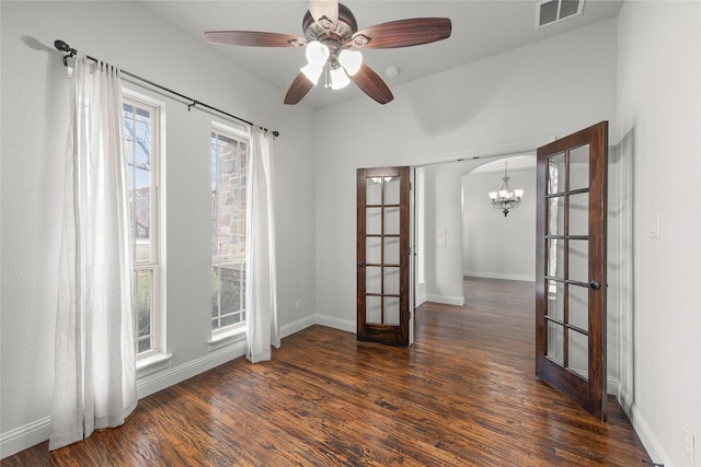 spare room with baseboards, visible vents, dark wood-style floors, french doors, and ceiling fan with notable chandelier