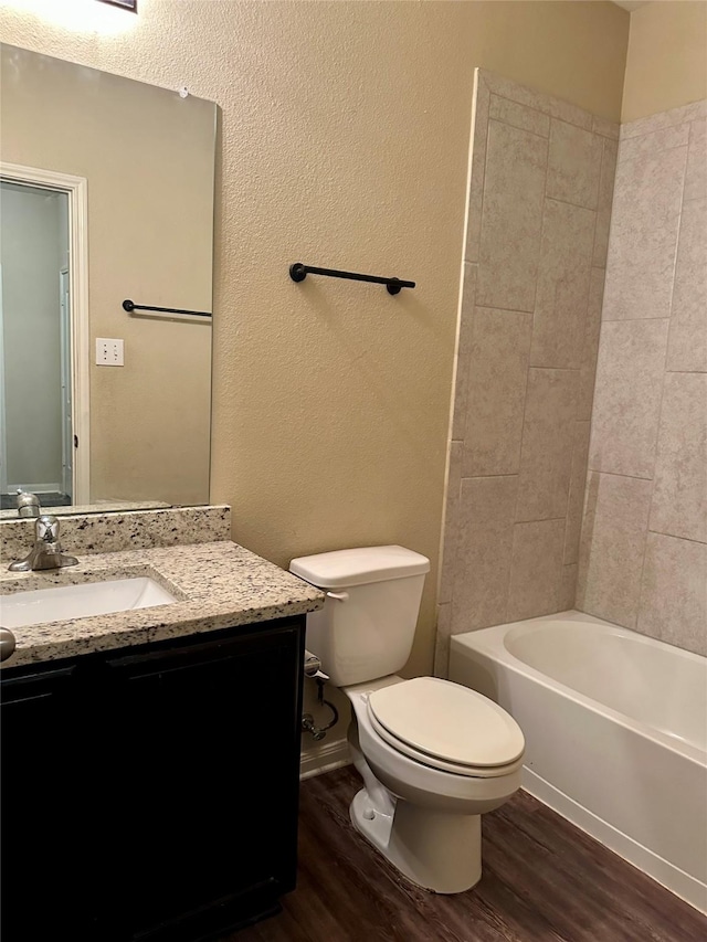 full bath with shower / bathtub combination, toilet, wood finished floors, vanity, and baseboards