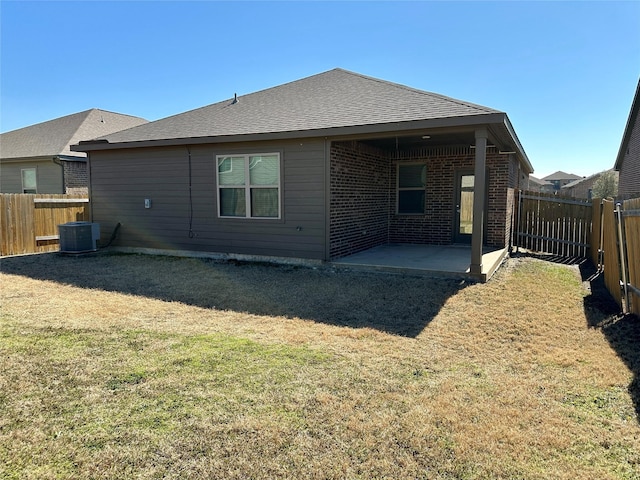 back of house featuring a patio area, a fenced backyard, central AC, and a yard