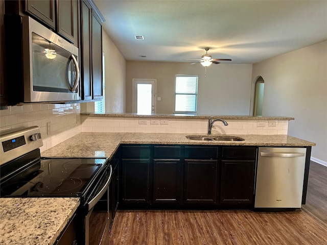 kitchen featuring dark wood-style flooring, a sink, visible vents, appliances with stainless steel finishes, and backsplash