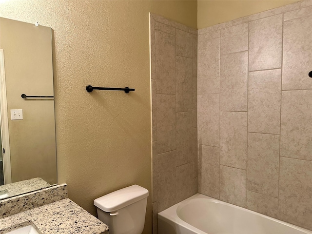 bathroom with toilet, shower / tub combination, vanity, and a textured wall