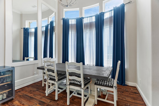 dining room with crown molding, wine cooler, baseboards, and dark wood-style flooring