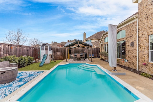 view of pool featuring a patio area, a gazebo, a playground, and a fenced backyard