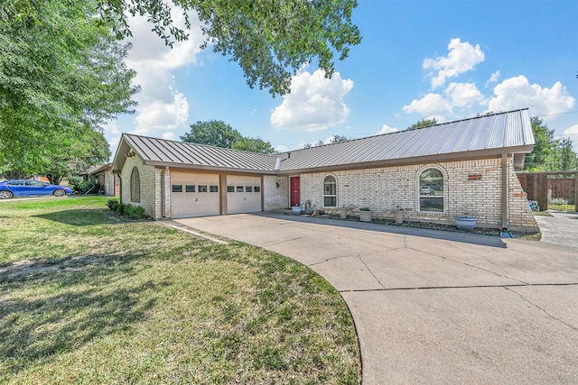 single story home featuring brick siding, concrete driveway, metal roof, an attached garage, and a front yard