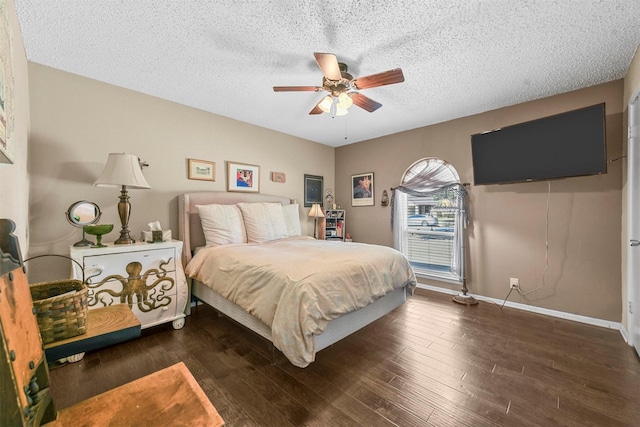 bedroom featuring a ceiling fan, dark wood finished floors, a textured ceiling, and baseboards