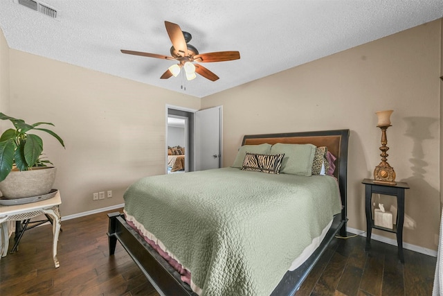 bedroom featuring baseboards, visible vents, a ceiling fan, dark wood-type flooring, and a textured ceiling