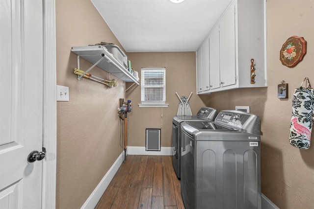 laundry room with cabinet space, baseboards, separate washer and dryer, and dark wood-type flooring