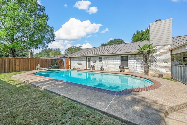 view of pool with a fenced in pool, a yard, a patio, a fenced backyard, and a diving board