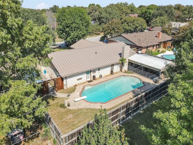 view of swimming pool with fence, a diving board, a fenced in pool, and a patio