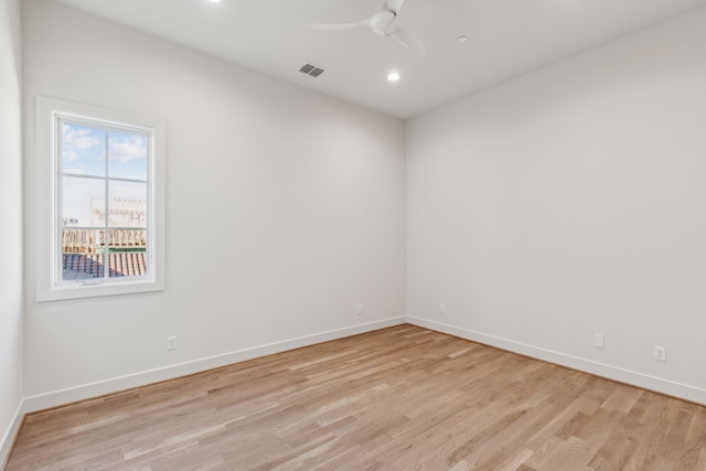 empty room with ceiling fan, light wood finished floors, visible vents, and baseboards