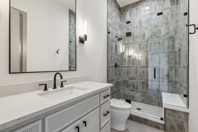 bathroom with toilet, a stall shower, and vanity