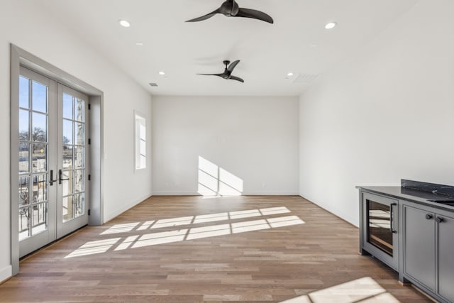 spare room with recessed lighting, french doors, beverage cooler, and light wood-style flooring