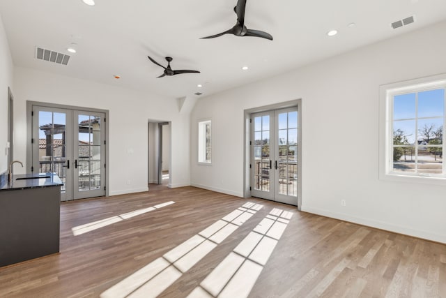 unfurnished living room with light wood-type flooring, french doors, visible vents, and recessed lighting