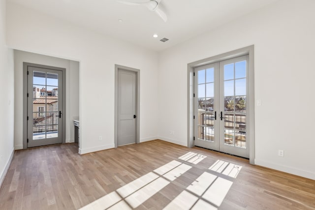 interior space with light wood-style floors, french doors, visible vents, and baseboards