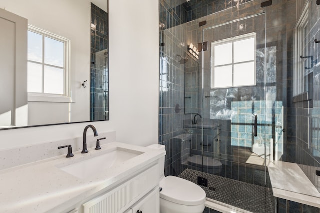 full bath with vanity, a shower stall, and toilet