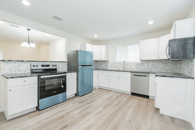 kitchen with hanging light fixtures, appliances with stainless steel finishes, visible vents, and white cabinets