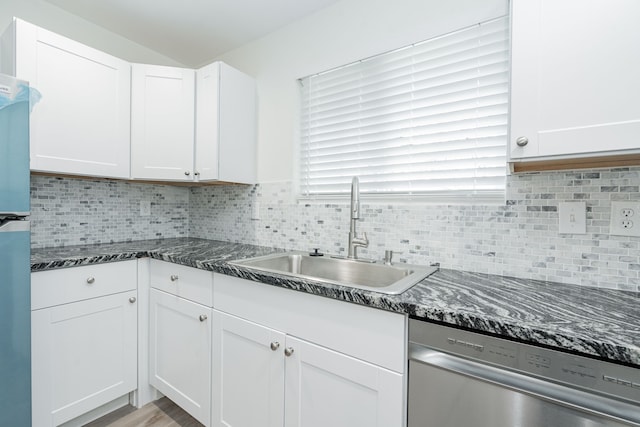 kitchen featuring decorative backsplash, dark stone counters, white cabinets, dishwasher, and a sink