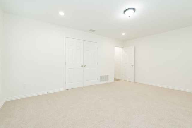 unfurnished room with baseboards, recessed lighting, visible vents, and light colored carpet