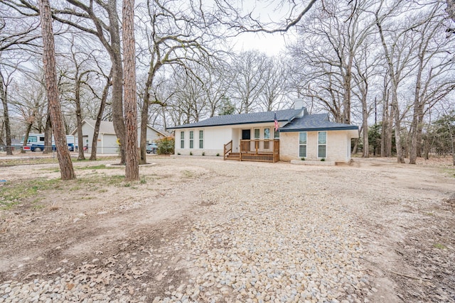 1345 Tawakoni Dr, West Tawakoni, TX 75474 - view of front of house with a chimney, a porch, dirt driveway, and a shingled roof