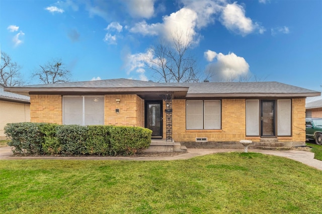 single story home with entry steps, brick siding, a front lawn, and roof with shingles