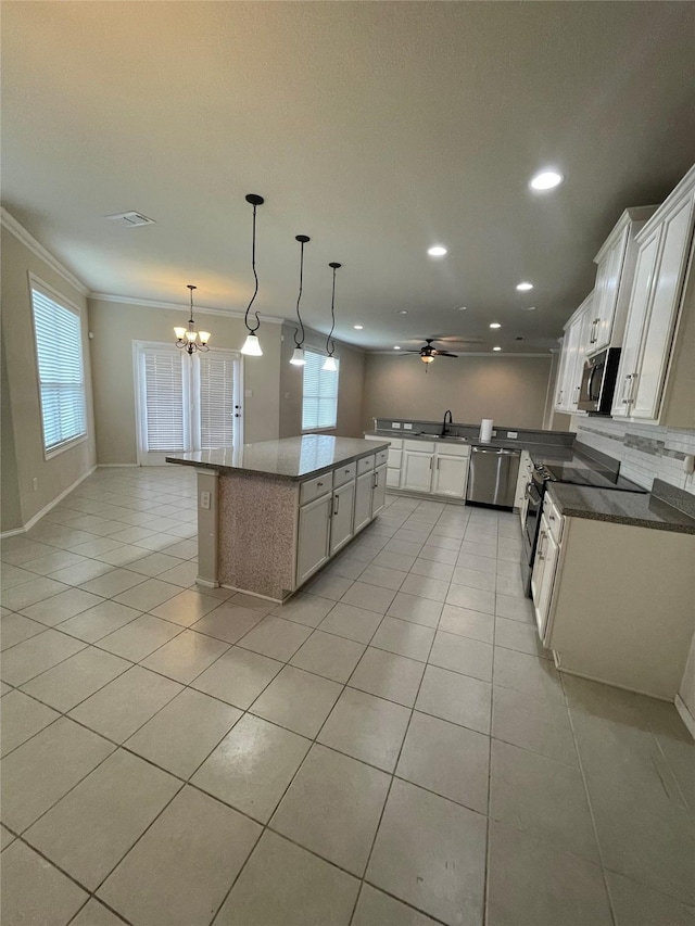 kitchen with stainless steel appliances, a center island, open floor plan, and white cabinets