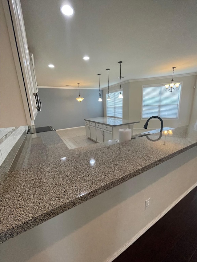 kitchen featuring hanging light fixtures, black electric stovetop, white cabinets, and recessed lighting