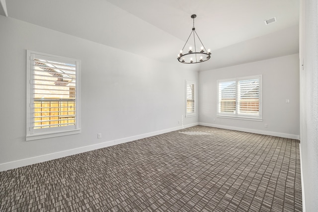 spare room with a chandelier, carpet flooring, visible vents, baseboards, and vaulted ceiling