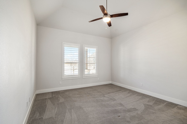 carpeted empty room featuring a ceiling fan, vaulted ceiling, and baseboards