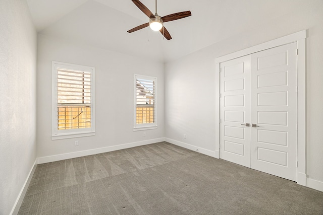 unfurnished bedroom with carpet, baseboards, vaulted ceiling, and a closet