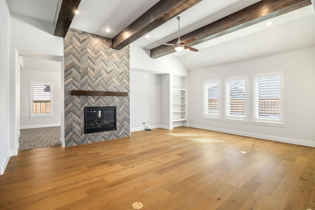 unfurnished living room with light wood-style floors, a tile fireplace, ceiling fan, and baseboards