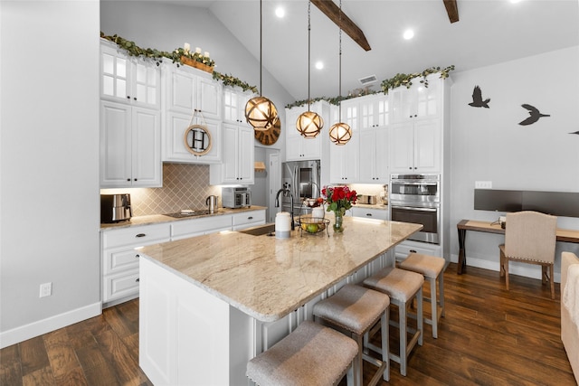 kitchen featuring white cabinets, a kitchen island with sink, and light stone countertops