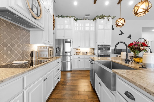 kitchen with glass insert cabinets, stainless steel appliances, hanging light fixtures, and white cabinetry