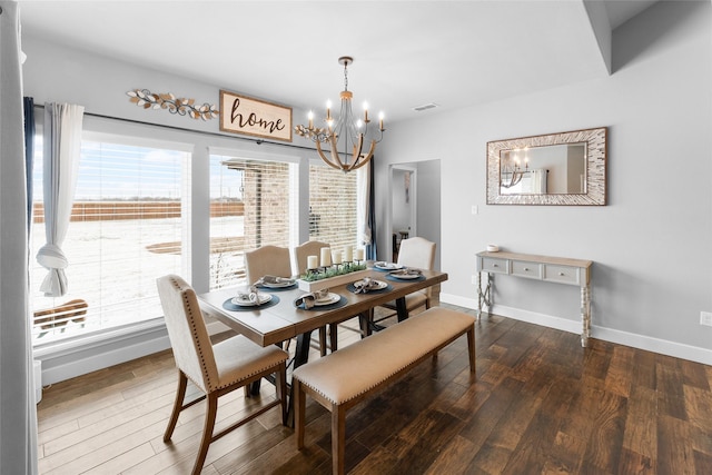 dining space featuring a healthy amount of sunlight, visible vents, a chandelier, and dark wood-type flooring