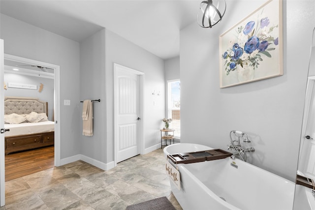 ensuite bathroom featuring a freestanding tub, baseboards, and ensuite bathroom