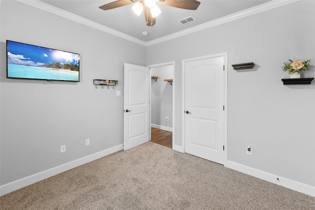 unfurnished bedroom featuring ornamental molding, carpet flooring, visible vents, and baseboards