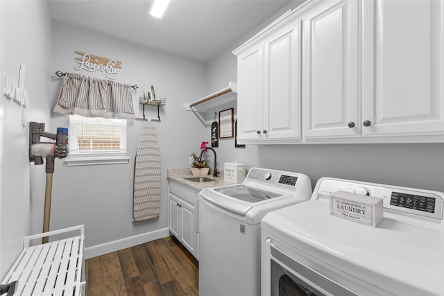 laundry area with dark wood finished floors, cabinet space, a sink, independent washer and dryer, and baseboards