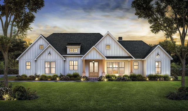 modern farmhouse featuring board and batten siding, covered porch, a lawn, and a shingled roof