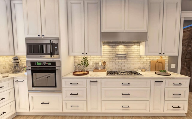 kitchen featuring stainless steel appliances, tasteful backsplash, ventilation hood, and light stone countertops