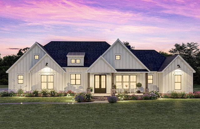 modern farmhouse featuring a yard, board and batten siding, and roof with shingles