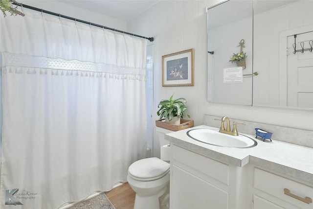 full bathroom featuring toilet, curtained shower, wood finished floors, and vanity