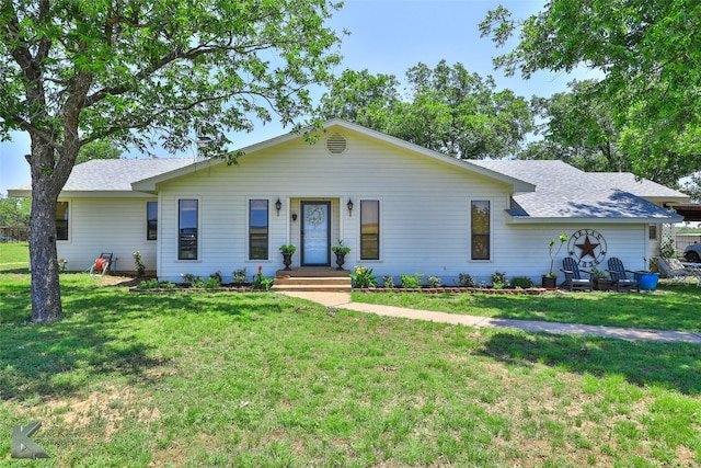 single story home featuring a front lawn and roof with shingles